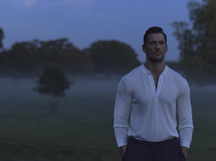 man walking across a gravel drive