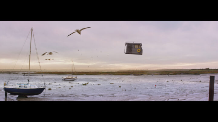 Still from campaign of shed flying over seafront