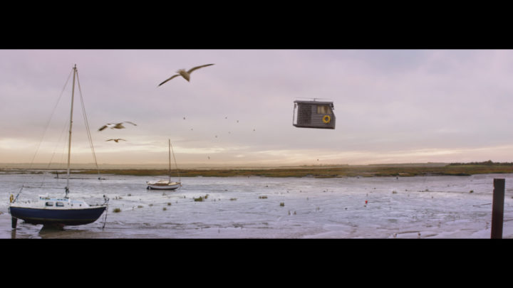 Still from campaign of shed flying over seafront
